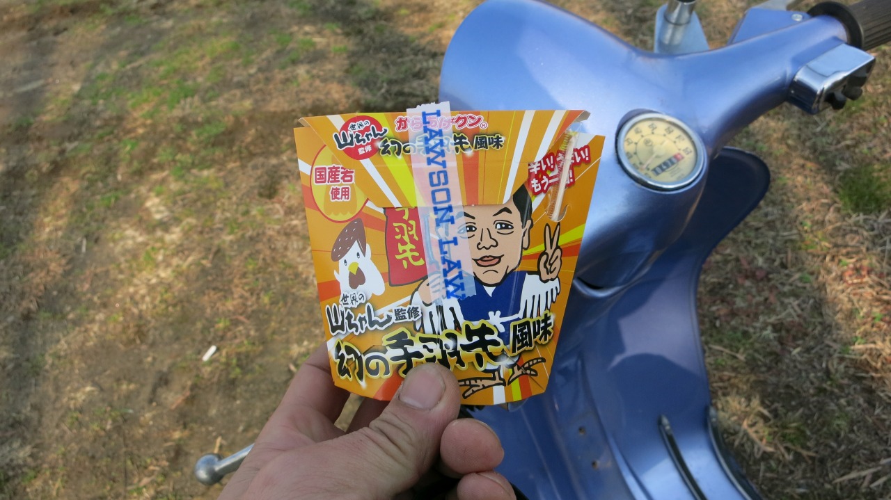キャブレター調整場で休憩しながら新作のからあげクンを楽しむ様子