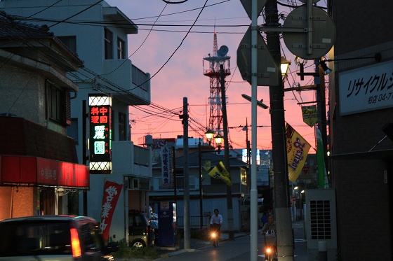 夕陽に染まる風景を見つめるベスパのシルエット