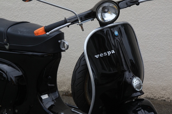 黒いボディーが美しいvespa100の斜め前からの写真。