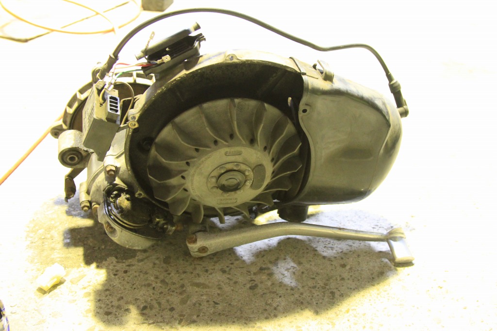 P200Eのエンジンの汚れを落としながら分解作業する様子
