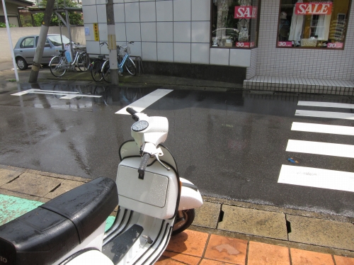 晴れているのに突然降り出した雨で、ベスパが濡れてしまった様子