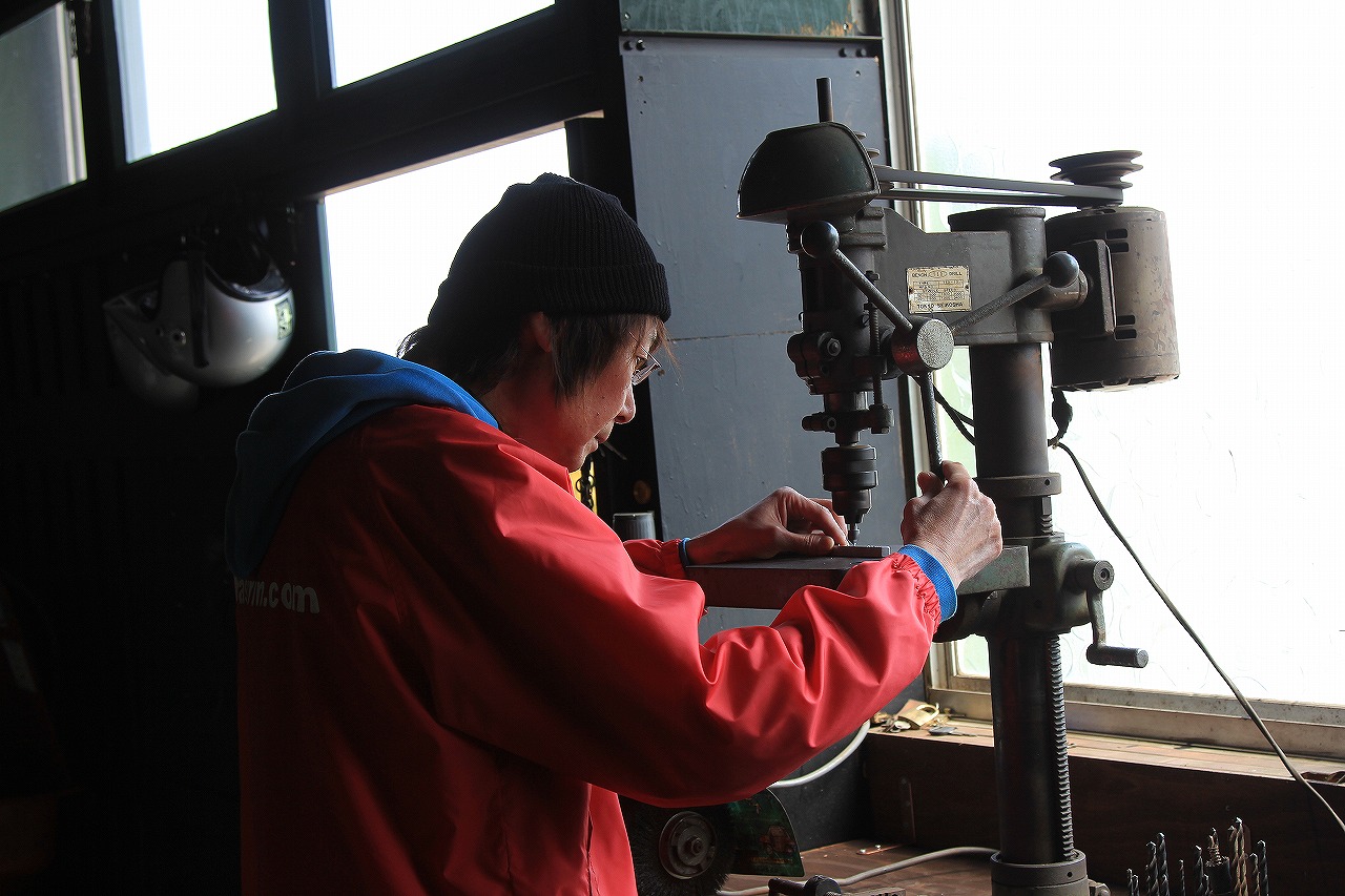 橋輪の社長が作業台で工具を使っている様子