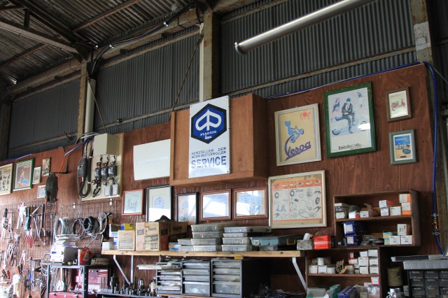 店舗の壁に掛けられた多数のベスパ関連ポスター