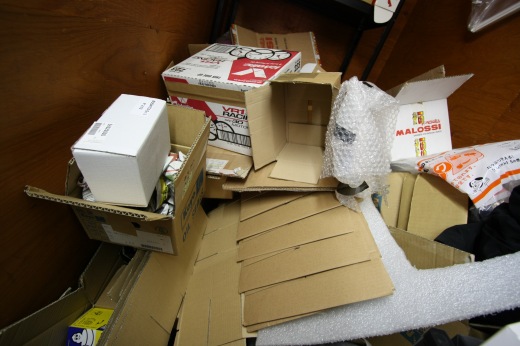 ストックルームに積まれたダンボールや梱包材が散乱している様子