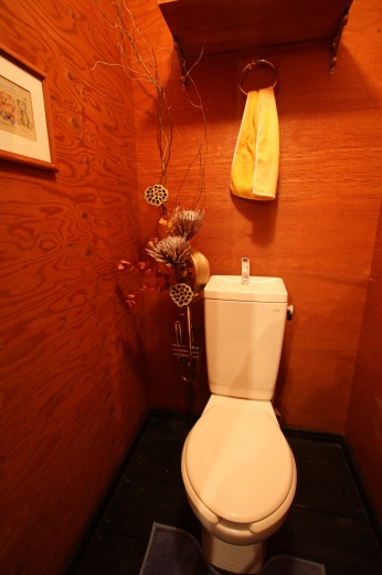 トイレの壁に花を飾り付ける作業中の様子