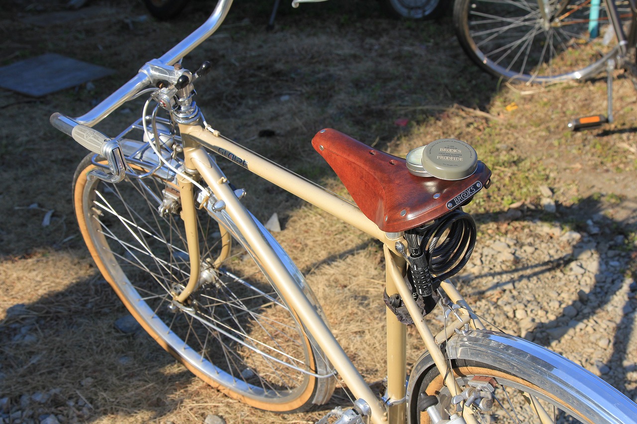 雨模様の中、サドルに油を差した自転車が停められている様子