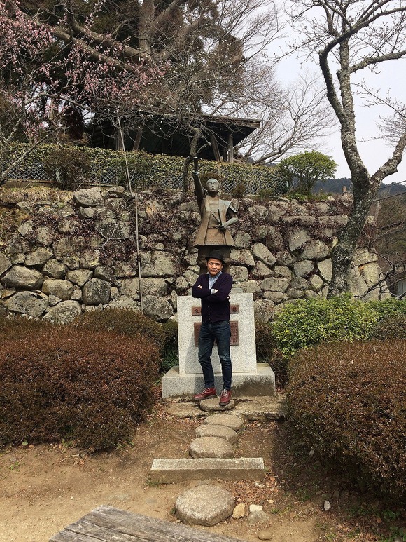 藤田小四郎の銅像と記念写真を撮る人物