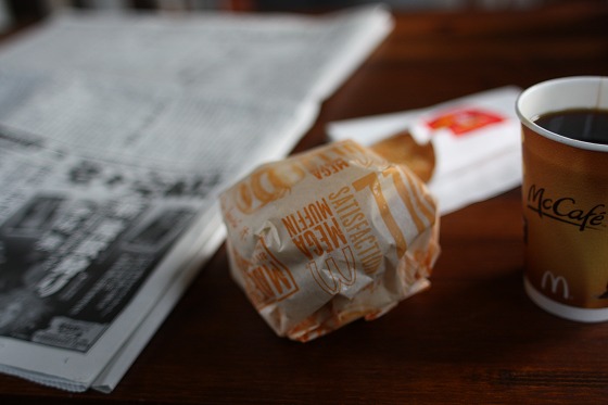 マクドナルドのハッシュポテトと新聞を並べた朝ごはん風景