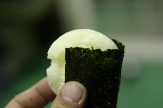 焼いた餅を海苔で包んで手に持っているところ