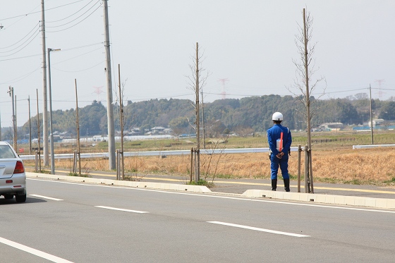 春の交通安全イベントで立っている警察官風コスチュームの人物。