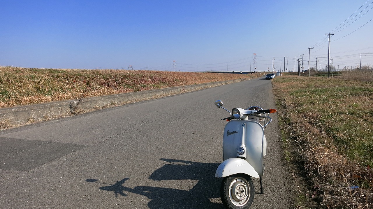 道沿いに並ぶ男性たちの後ろ姿と物々しい雰囲気