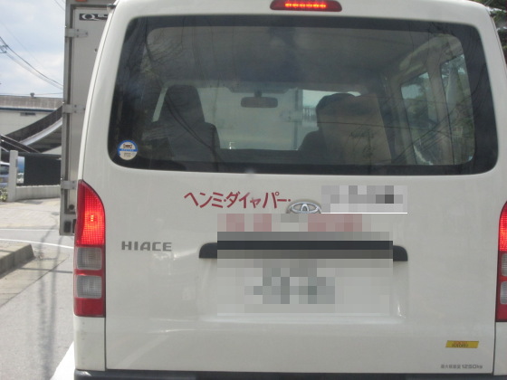 読みにくい会社名の看板を見つめる信号待ち