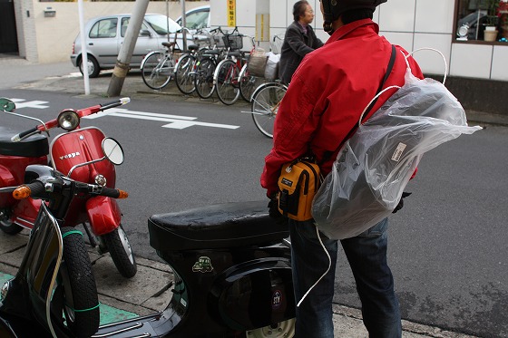 シートを背負って帰るバイク乗りのお客様の後ろ姿