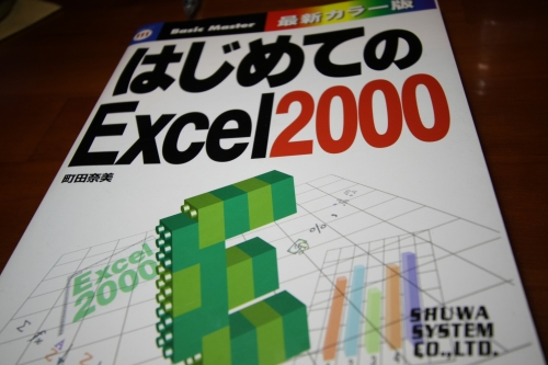 「はじめてのExcel」本を参考に事務作業を行っている様子