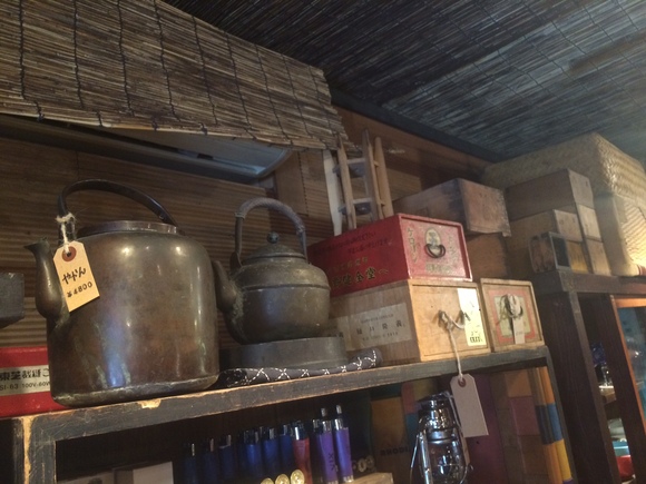 工芸品やキャンプ道具が並んだ木製ラックの店内風景