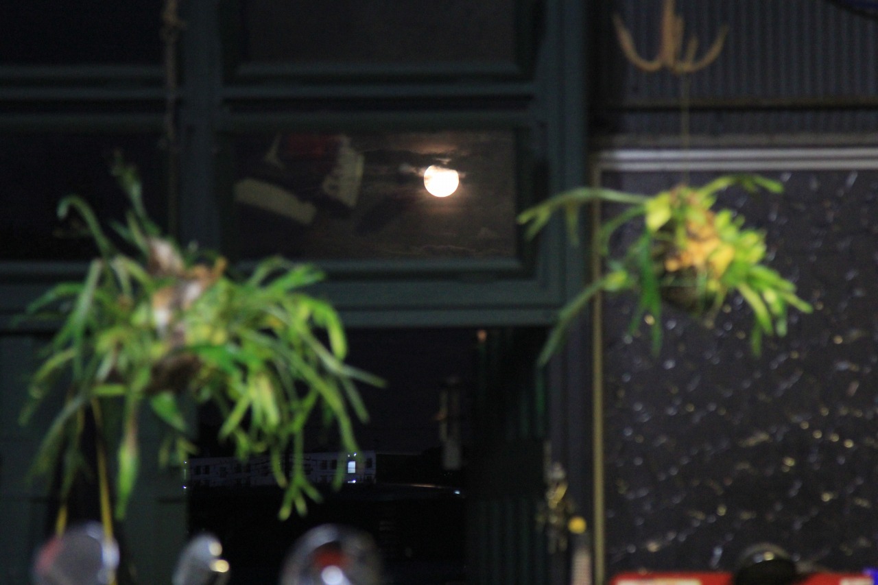 夜、窓の外に綺麗に輝く月が見える店内の風景。