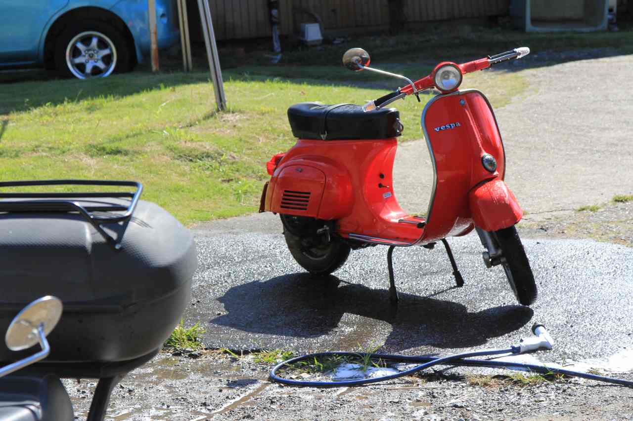 洗車されてボディが濡れた赤いVespa50s