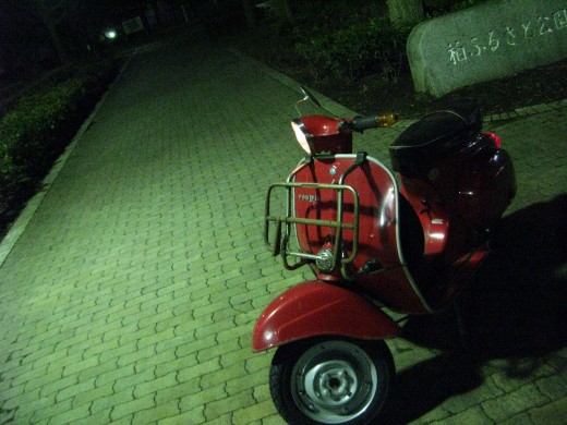 白いベスパと田んぼの用水路が広がるのどかな風景
