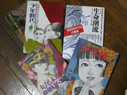 木の床に並べられた本や雑誌、生命潮流などの表紙が見える