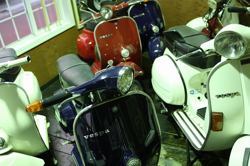 店内に並べられた複数のVespa、手前には紺色のET3。