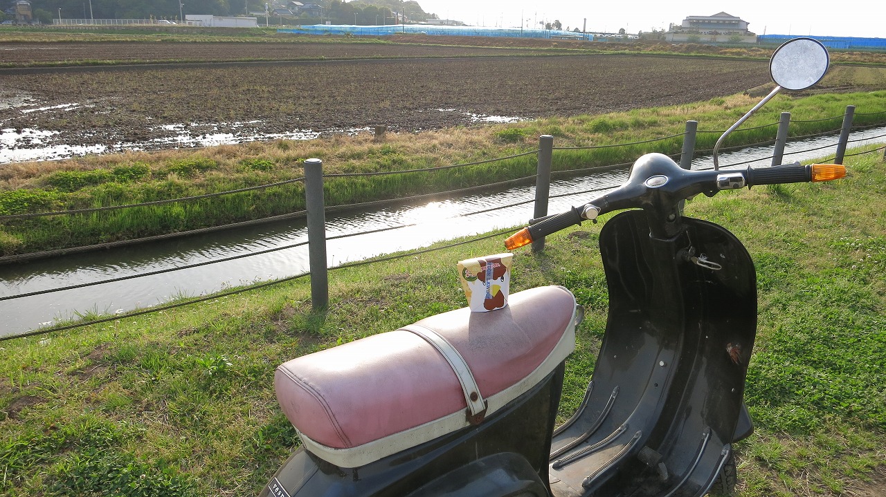 ベスパで試運転中にからあげクンを手にする様子