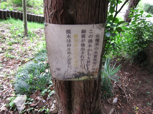 湧水地の背後に立っていた「大腸菌注意」の看板