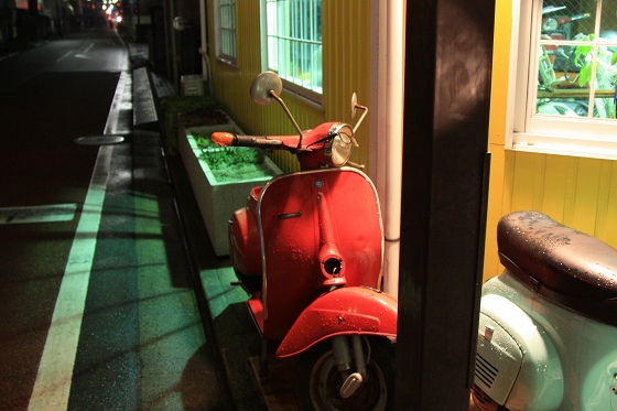 メガネが描かれたカスタム中のベスパ看板車