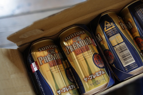 ビールの差し入れを喜ぶ店主の様子と缶ビール