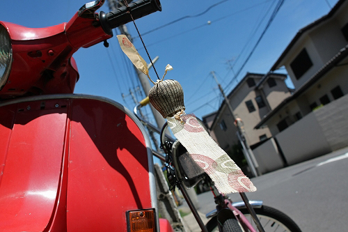 夏の街角に停められたベスパの印象的なカット