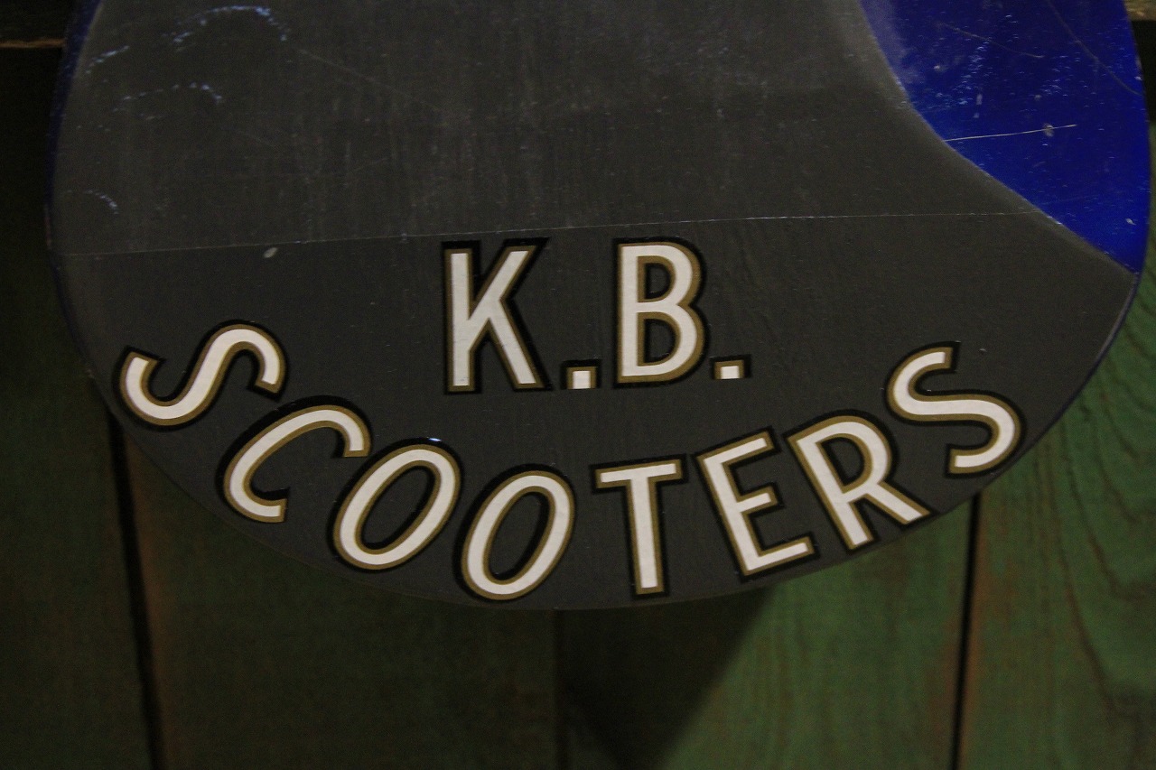 「K.B.SCOOTERS」の文字ステッカーが貼られたギター