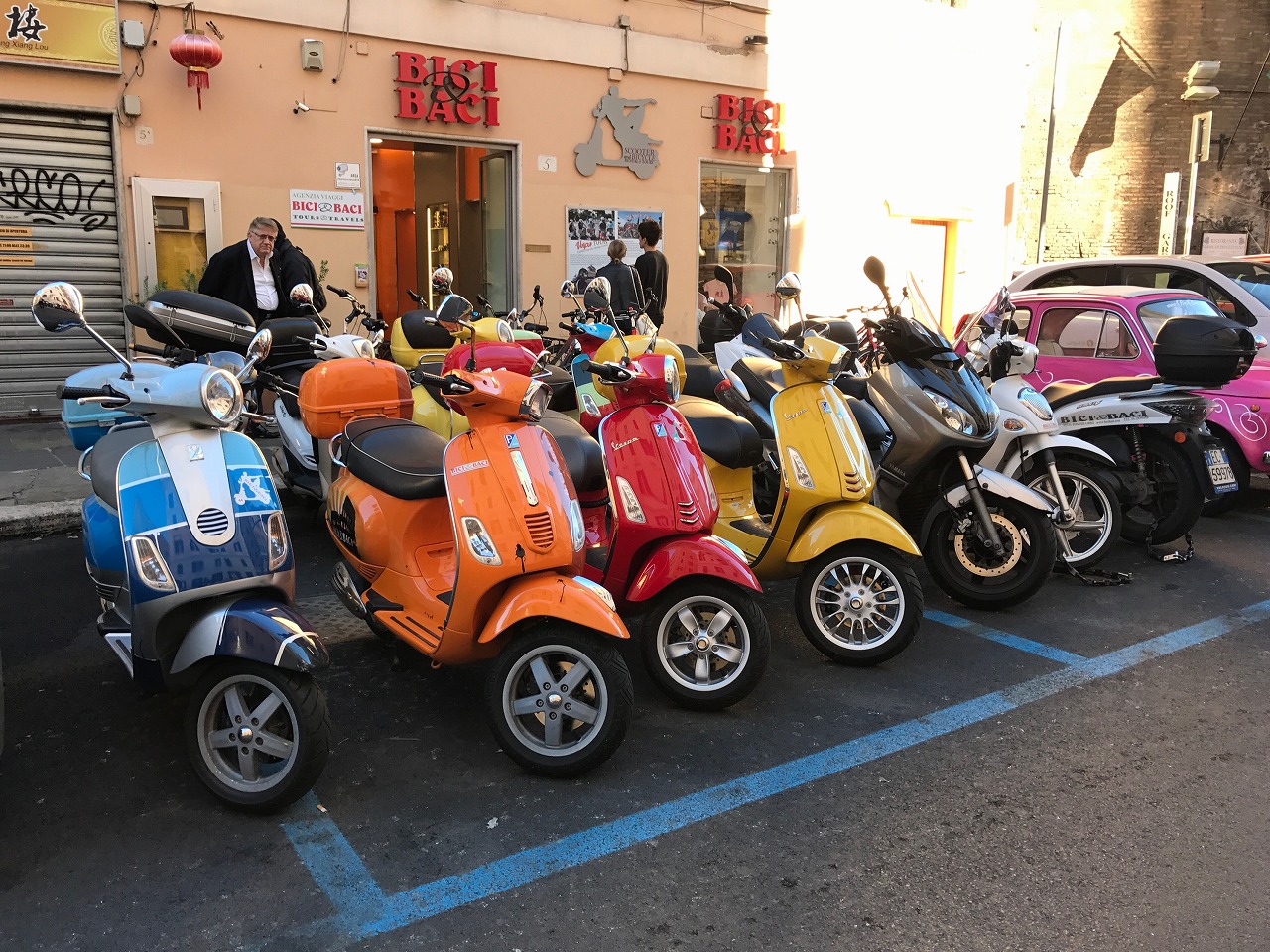 イタリアの街角に並ぶベスパと石畳の風景
