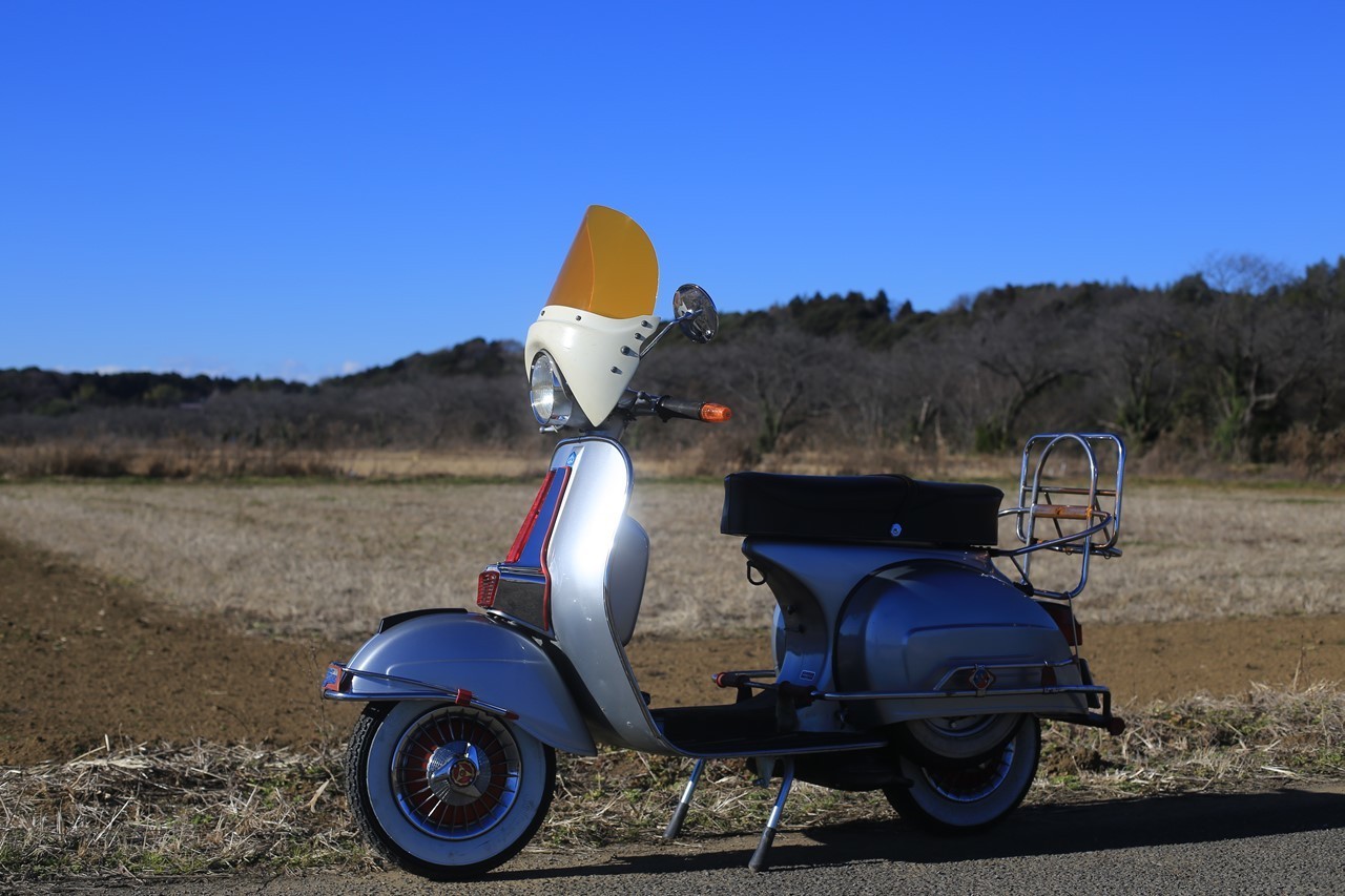 田園風景を背景にしたベスパ ラリー200の横姿
