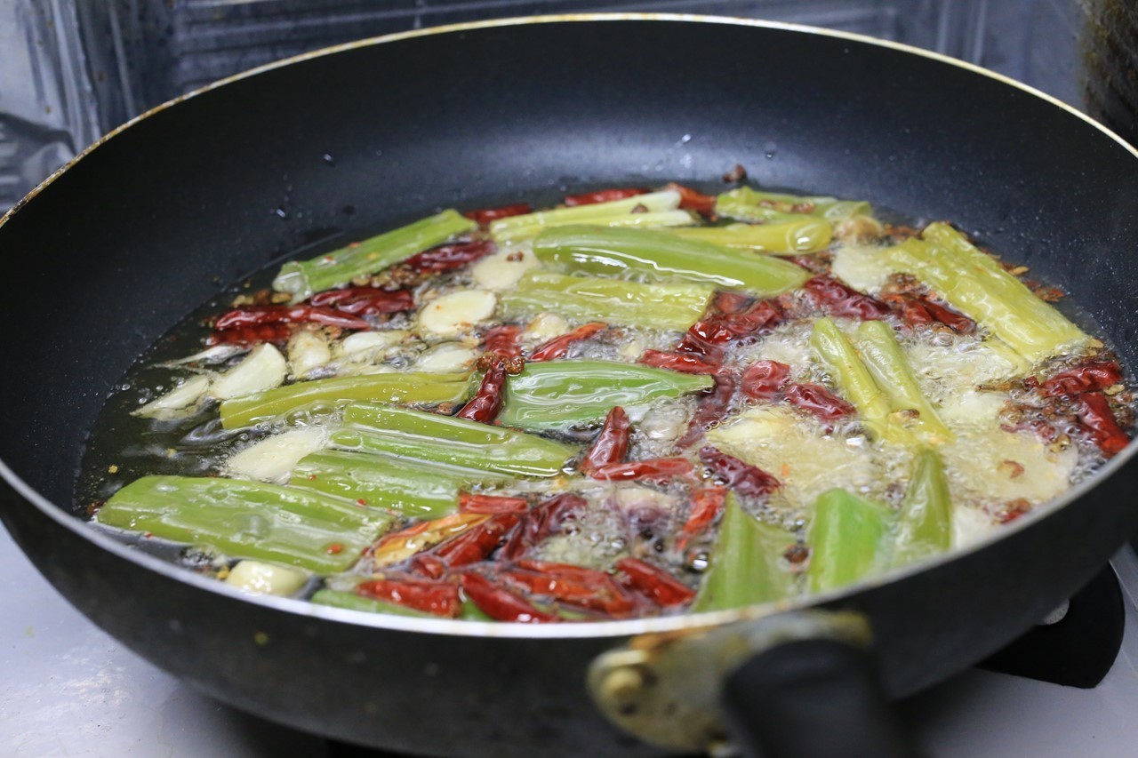 香味野菜を油で炒めている様子