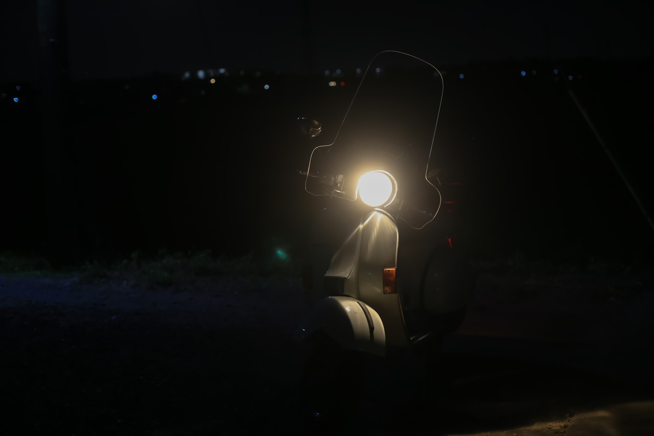 暗い道で試運転中のベスパ
