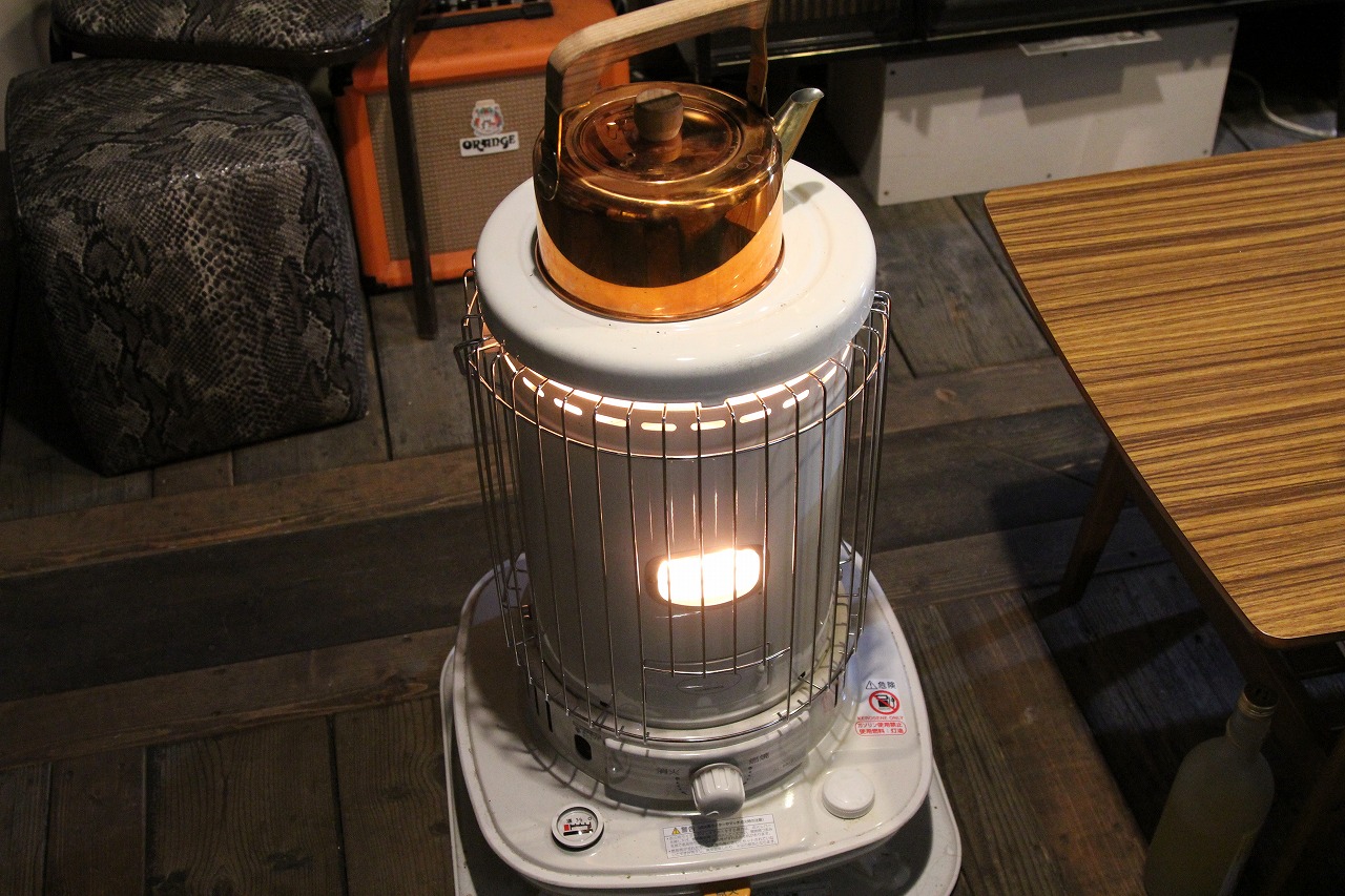 作業の合間にストーブで指を温める様子