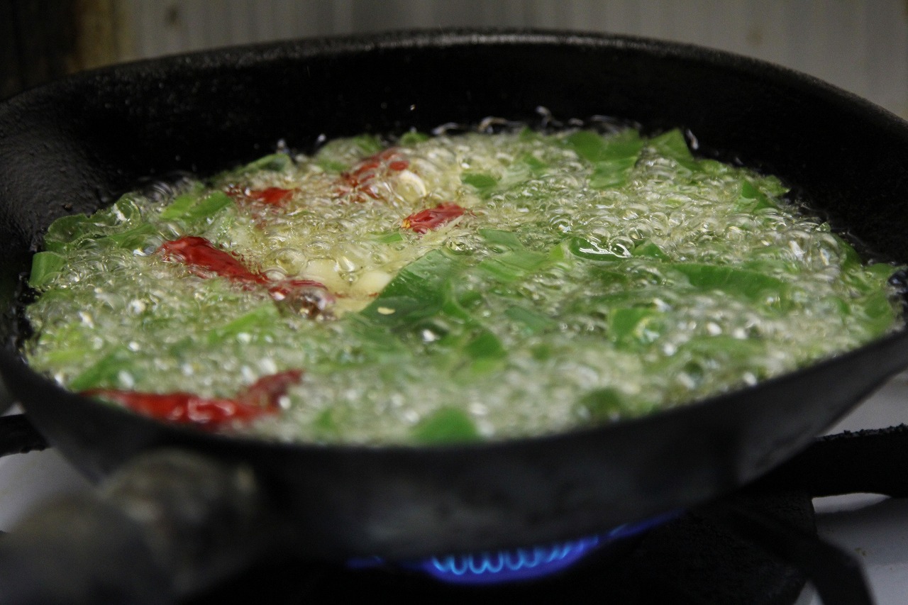 熱した油に香味野菜を投入する瞬間