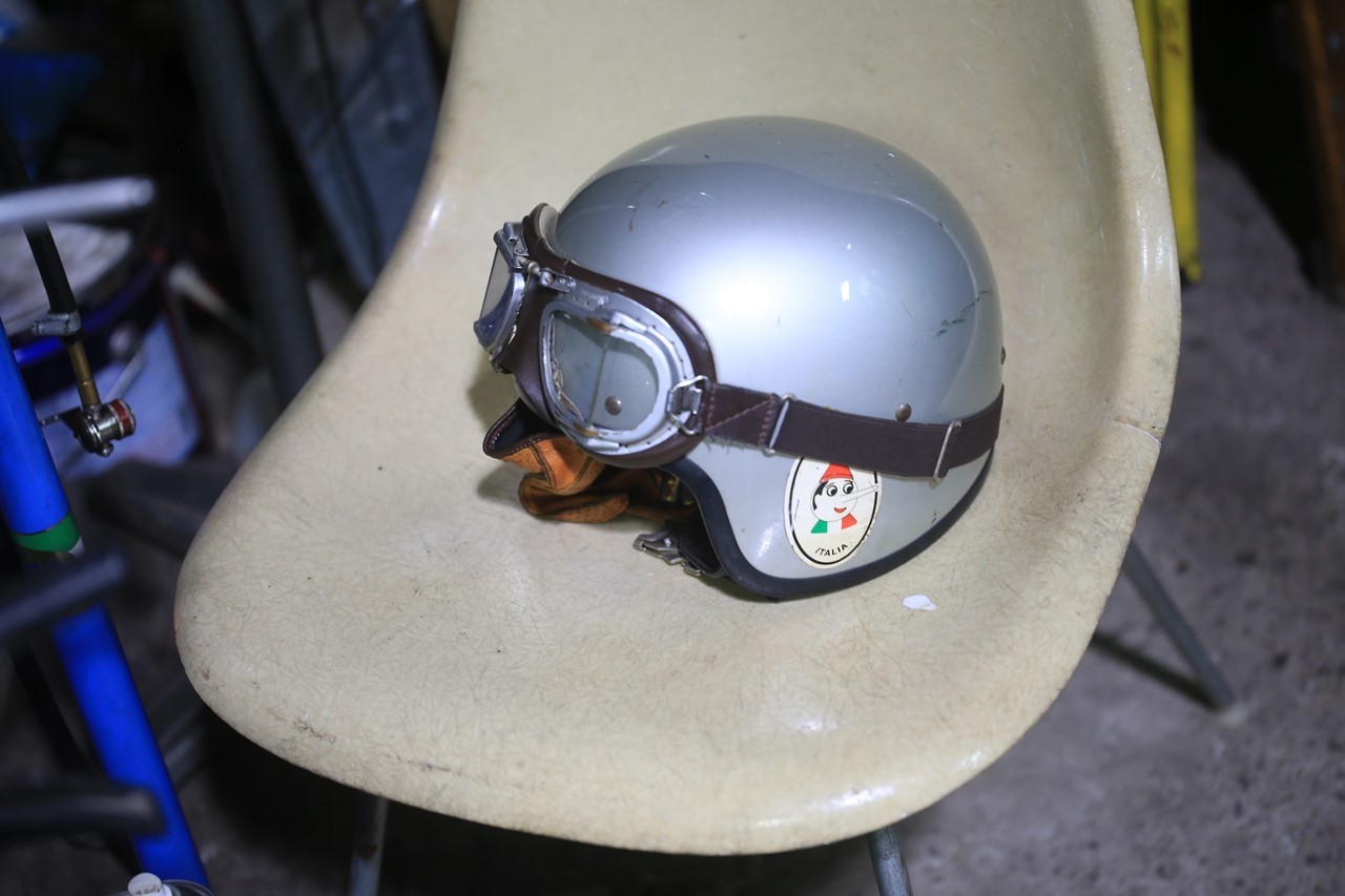 シルバーのジェットヘルメットとゴーグルが椅子の上に置かれている