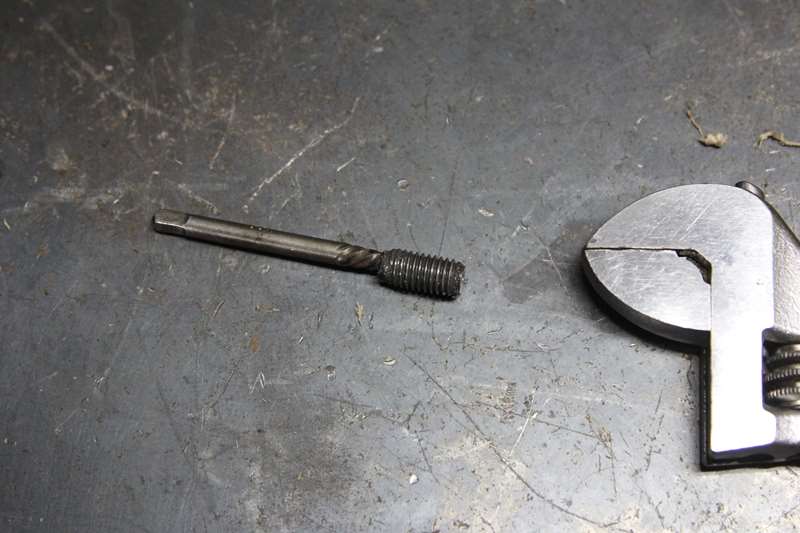 作業台の上に取り外した折れたボルトと工具が置かれている写真
