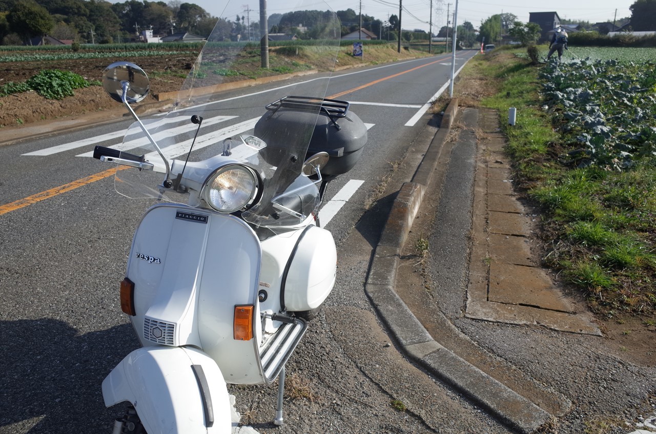朝の道路脇に停めた白いベスパP200E