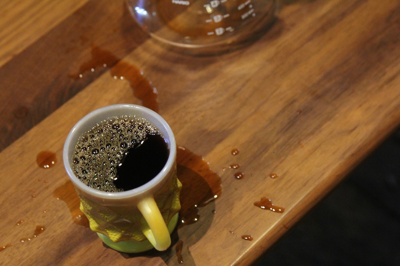 コーヒーを入れている最中にくしゃみをしてこぼした様子