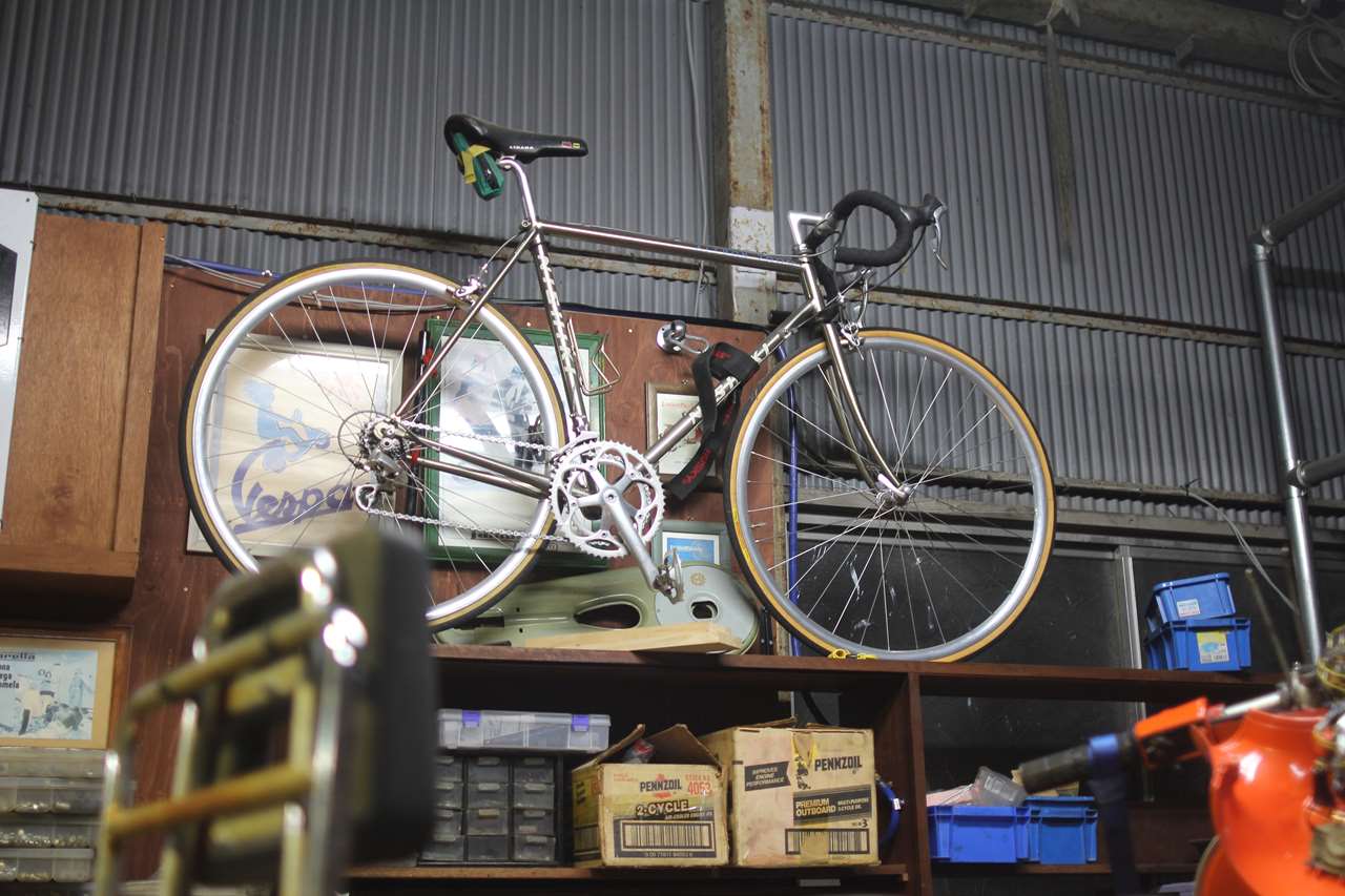棚の上の自転車を下ろして運動しようか悩む図